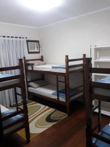 a room with two bunk beds and two chairs at Blu Hostel in Blumenau