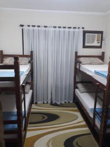 a room with three bunk beds and a window at Blu Hostel in Blumenau