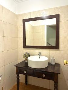 ein Bad mit einem Waschbecken und einem Spiegel in der Unterkunft Casa das Ginjas in São Vicente