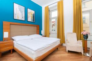 a bedroom with a large bed and a chair at Moonlight Apartments Old Town in Prague