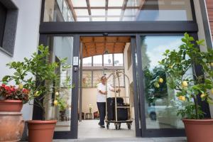 a man standing outside of a door with a suitcase at Hotel La Villetta in Calenzano