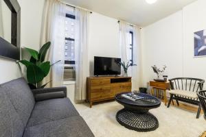 a living room with a couch and a tv at Apartment 282: Columbus Circle in New York