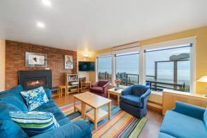 a living room with a blue couch and chairs and a fireplace at Neahkahnie MCA#50060 in Manzanita