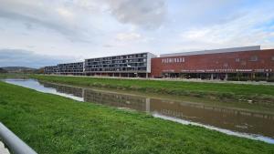 a building next to a river next to a building at Apartmán PROMENÁDA in Nitra