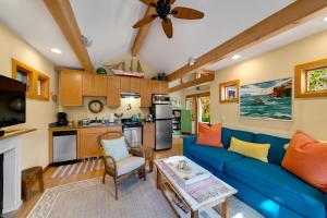 a living room with a blue couch and a kitchen at Lil Love Shack in Manzanita +31 photos
