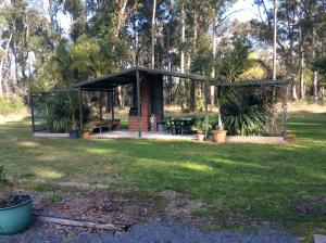 un cenador con una mesa de picnic en un parque en Snowy River Lodge Motel en Orbost