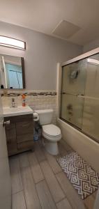 a bathroom with a toilet and a sink and a shower at Wonderful 3BR apartment in NYC! in New York