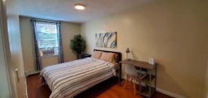 a bedroom with a bed and a desk and a window at Wonderful 3BR apartment in NYC! in New York
