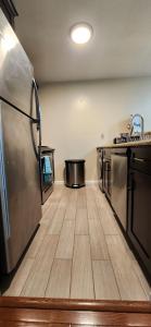 a kitchen with wooden floors and stainless steel appliances at Wonderful 3BR apartment in NYC! in New York