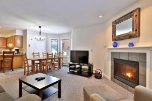 a living room with a fireplace and a dining room at Beautifully decorated 3 bedroom condo nestled Slopeside on Pico Mountain Ski-in Ski-out G101 in Killington
