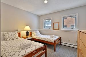 a bedroom with a bed and a couch and a window at Beautifully decorated 3 bedroom condo nestled Slopeside on Pico Mountain Ski-in Ski-out G101 in Killington