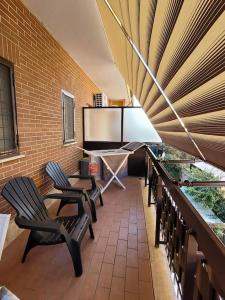 grupa krzeseł siedzących na balkonie w obiekcie Appartamento ai Castelli Romani w mieście Marino