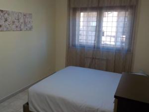 - une chambre avec un lit blanc et une fenêtre dans l'établissement Appartamento ai Castelli Romani, à Marino