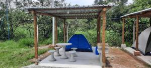 un refugio con una mesa y una tienda en Camping e Pousada Paiol, en Águas da Prata