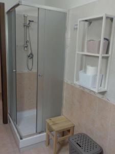 ein Bad mit einer Dusche, einer Bank und einem Stuhl in der Unterkunft Appartamento ai Castelli Romani in Marino