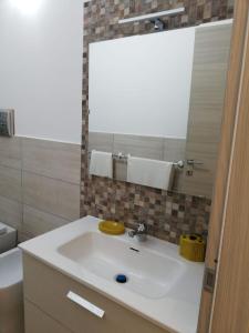 a bathroom with a white sink and a mirror at Blu Mare Lampedusa Bed And Breakfast in Lampedusa