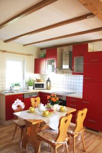 a kitchen with red cabinets and a table and chairs at Ferienhaus Harzblick in Güntersberge
