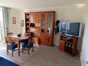 Sala de estar con mesa de comedor y TV en Casa Serena, en Cave