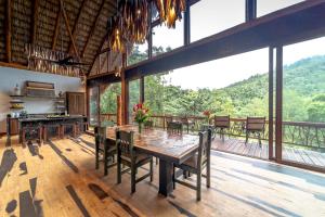 Good Living CampにあるValley Stream Private Edenのテーブルと椅子と窓のあるダイニングルーム