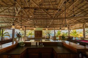 a restaurant with a large ceiling with wooden beams at Little Harvest Caye - Your Own Private Island in Placencia