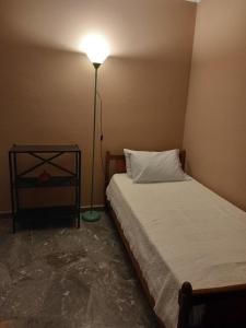 una camera da letto con un letto con una lampada accanto di Apartment at Tsoutsouros a Tsoutsouros