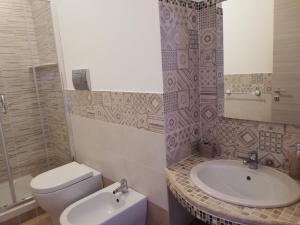 a bathroom with a white toilet and a sink at Blu Mare Lampedusa Bed And Breakfast in Lampedusa