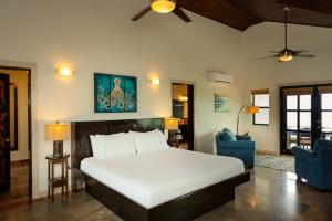 a bedroom with a bed and two blue chairs at 3 Story Oceanfront Luxury Villa 5 Bedroom w Pool in Maya Beach +42 photos