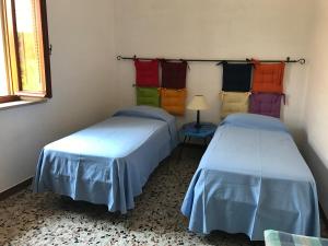 FaugliaにあるPoggio dei Michelazziの異なる色のシーツを使用した客室内のベッド2台