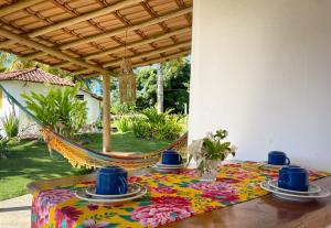 a table with blue cups and plates on a hammock at Canto do Mar - Chalés com vista pro Mar - Cumuruxatiba in Cumuruxatiba