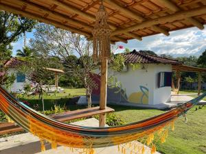 a hammock in front of a house at Canto do Mar - Chalés com vista pro Mar - Cumuruxatiba in Cumuruxatiba