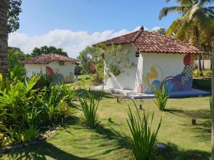 a house with a painting on it in a yard at Canto do Mar - Chalés com vista pro Mar - Cumuruxatiba in Cumuruxatiba