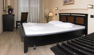 a bedroom with a large bed with white sheets at Vila Caviar in Sulina