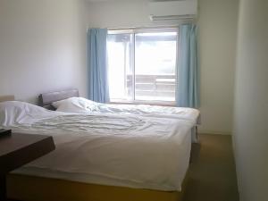 a white bed in a room with a window at Futtsu Sea House INN Kanaya - Vacation STAY 95628v in Futtsu