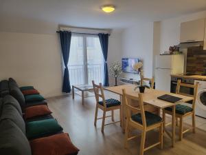 a kitchen and living room with a table and a couch at Studio cosy à 5 minutes de DISNEYLAND PARIS in Chalifert