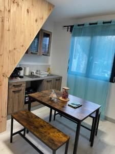 eine Küche mit einem Holztisch und einer Holzbank in der Unterkunft Logementprivatif en famille à Disney in Montry