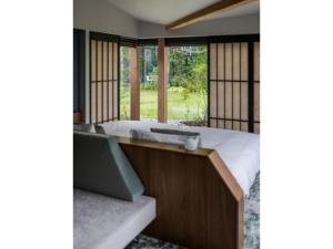 1 dormitorio con cama, bañera y ventanas en ITOMACHI HOTEL 0 - Vacation STAY 97807v, en Saijo