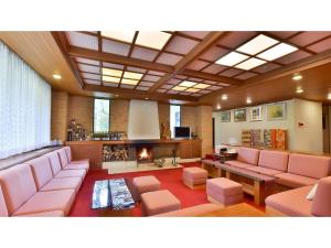 Oyado Kotobuki - Vacation STAY 97600v في Yokokura: غرفة معيشة مع كنب وردي ومدفأة