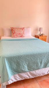a bedroom with a large bed with a blue blanket at Seacastles by the beach/pool in Montego Bay