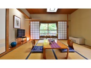 Oyado Kotobuki - Vacation STAY 97600v في Yokokura: غرفة معيشة مع طاولة وكراسي
