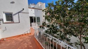 einen Balkon mit einem Baum neben einem Gebäude in der Unterkunft Apartamento nuevo en Terrassa Centro in Terrassa