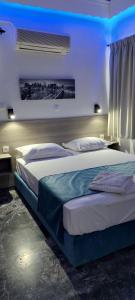 1 dormitorio con 2 camas y luz azul en San Georgio Hotel, en Tsoutsouros