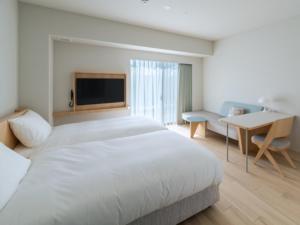 1 dormitorio con 1 cama, escritorio y TV en ITOMACHI HOTEL 0 - Vacation STAY 97739v, en Saijo