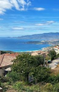 - une vue sur l'océan depuis une colline avec des maisons dans l'établissement Maison de vacances vue mer, à Calcatoggio