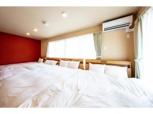 een groot wit bed in een kamer met een raam bij VILLA KOSHIDO KOTONI annex - Vacation STAY 97687v in Sapporo