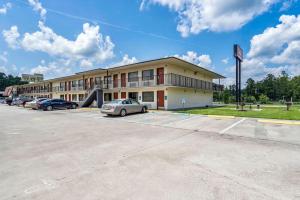 a building with cars parked in a parking lot at Red Roof Inn MacClenny in Macclenny