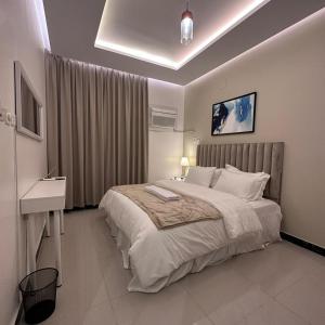 a bedroom with a large bed and a sink in it at رغيد للشقق الفندقية حائل in Hail