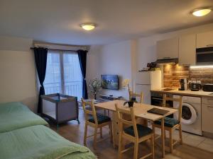 a kitchen and dining room with a table and chairs at Studio cosy à 5 minutes de DISNEYLAND PARIS in Chalifert