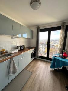 a kitchen with a table and a large window at IMEPA Appart 47m2/ Beau 2 pièces in Rouen