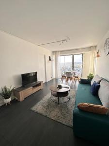 - un salon avec un canapé vert et une table dans l'établissement IMEPA Appart 47m2/ Beau 2 pièces, à Rouen