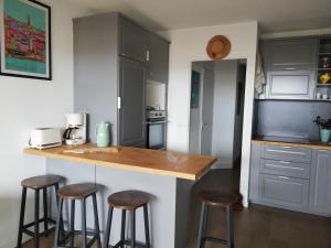a kitchen with a counter and stools in it at Studio cosy in Mimizan